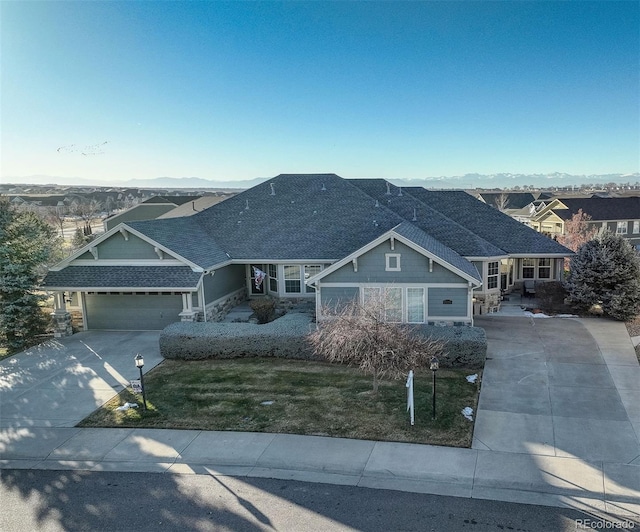 view of front of house with a garage, a mountain view, and a front yard