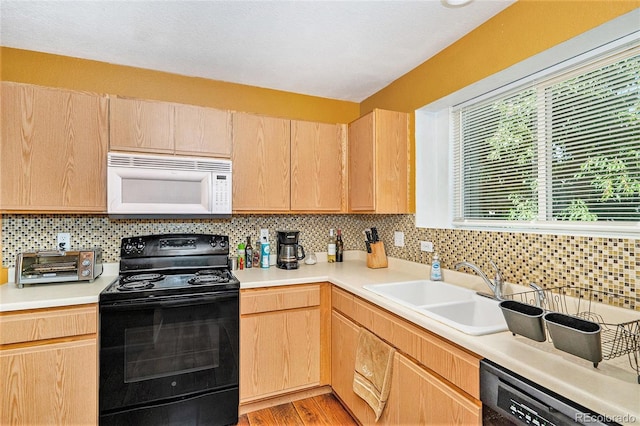 18786 E 57th Pl Unit A, Denver, CO 80249 - kitchen with black appliances, light brown cabinetry, light countertops, and backsplash