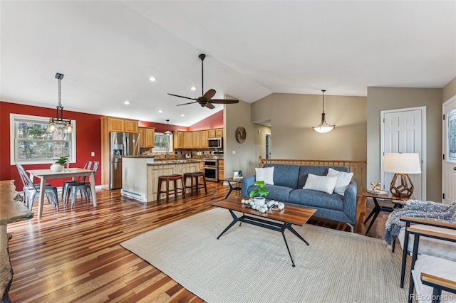 living area featuring vaulted ceiling, wood finished floors, a ceiling fan, and recessed lighting