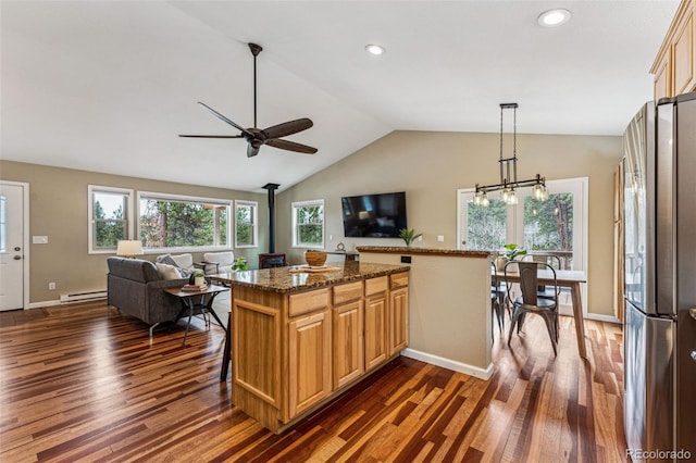 kitchen featuring a wealth of natural light, freestanding refrigerator, a wood stove, and a baseboard radiator