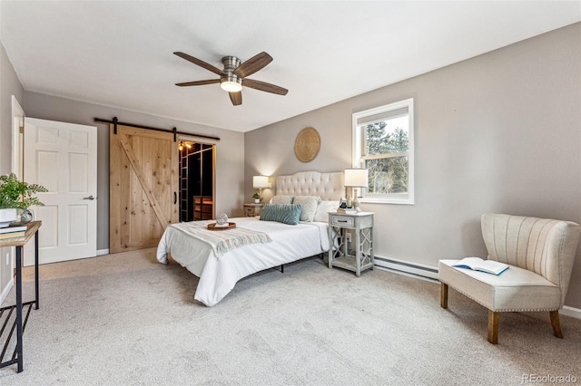 bedroom featuring a barn door, a ceiling fan, a spacious closet, carpet floors, and a baseboard heating unit