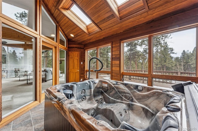 sunroom featuring vaulted ceiling with skylight, wooden ceiling, and a jacuzzi