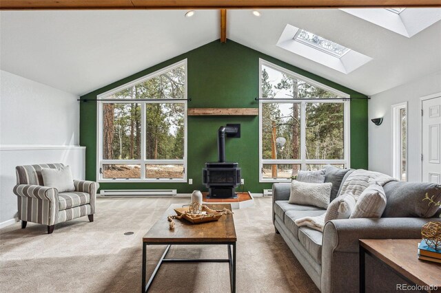 living area featuring a baseboard heating unit, baseboards, lofted ceiling with skylight, carpet, and a wood stove