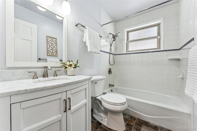 full bath featuring bathtub / shower combination, stone finish floor, vanity, and toilet