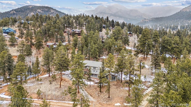 birds eye view of property featuring a mountain view and a wooded view