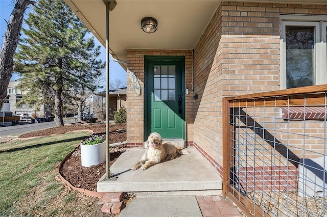 doorway to property featuring brick siding