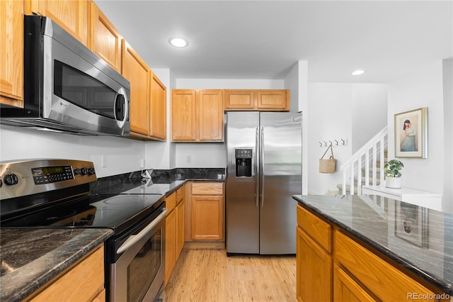 15963 Rock Crystal Dr, Parker, CO 80134 - kitchen featuring appliances with stainless steel finishes, light wood-type flooring, dark stone countertops, and recessed lighting