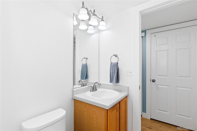 15963 Rock Crystal Dr, Parker, CO 80134 - bathroom featuring vanity, toilet, wood finished floors, and a chandelier