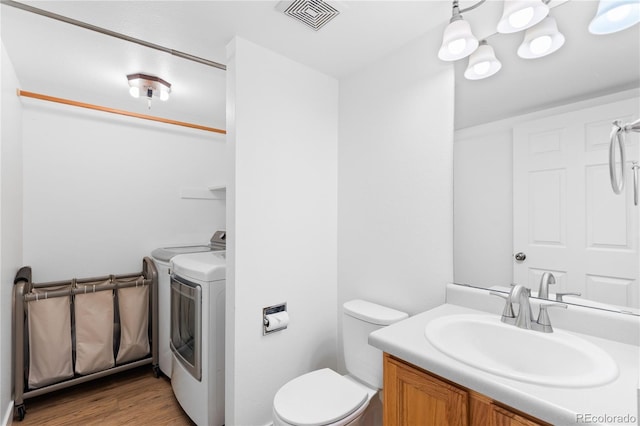 15963 Rock Crystal Dr, Parker, CO 80134 - bathroom featuring vanity, toilet, washer and dryer, and wood finished floors