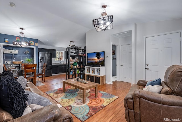 living room featuring vaulted ceiling and wood-type flooring