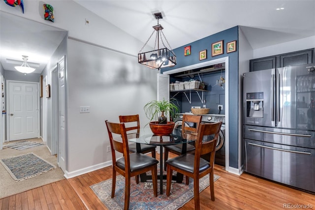 dining room with light hardwood / wood-style flooring and lofted ceiling