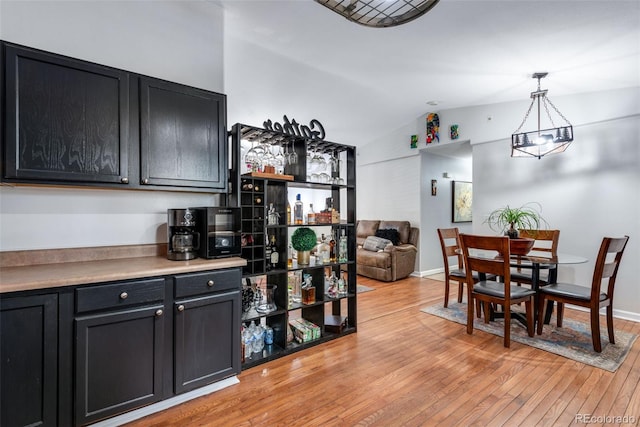 interior space featuring light hardwood / wood-style floors, an inviting chandelier, and lofted ceiling