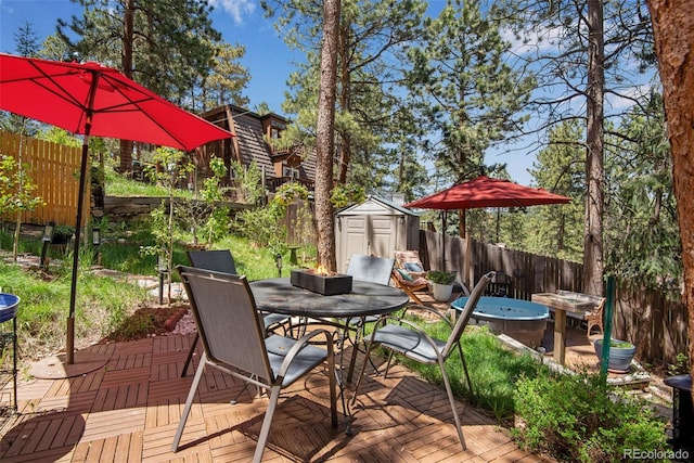 view of patio / terrace with a deck and a storage shed