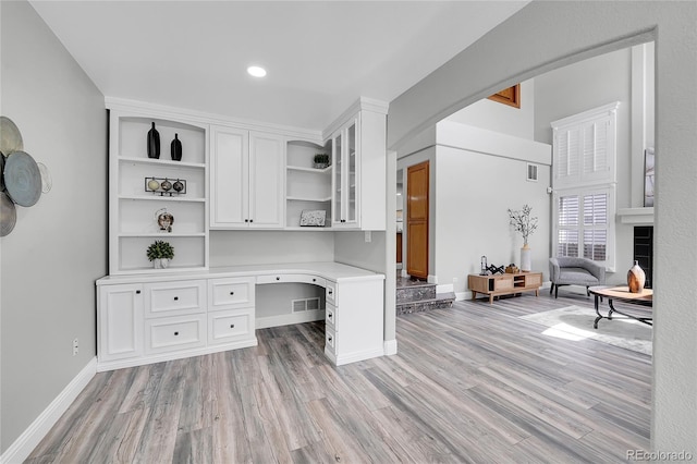 19731 E 40th Ave, Denver, CO 80249 - home office featuring built in study area, light wood-style floors, recessed lighting, and arched walkways