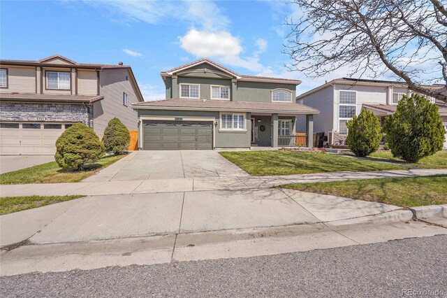 19731 E 40th Ave, Denver, CO 80249 - traditional-style house featuring concrete driveway, a garage, a front yard, a porch, and stucco siding