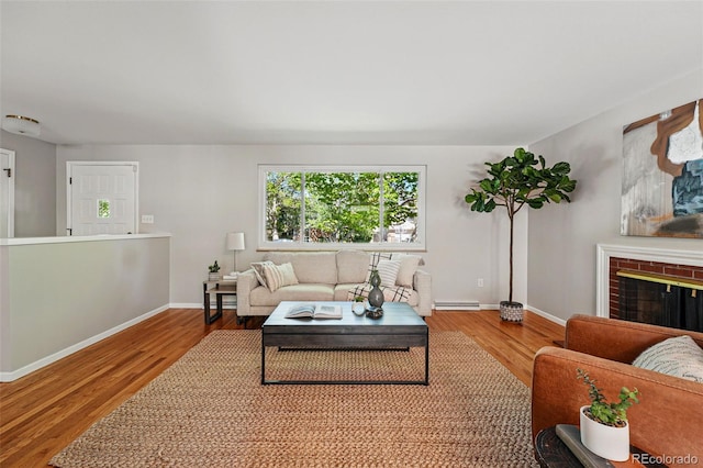 1905 S Linden Ct, Denver, CO 80224 - living area featuring baseboard heating, wood finished floors, and a brick fireplace