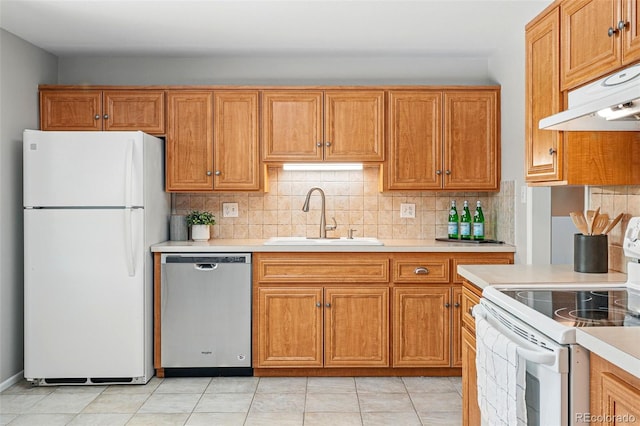 1905 S Linden Ct, Denver, CO 80224 - kitchen with white appliances, under cabinet range hood, light countertops, decorative backsplash, and brown cabinets