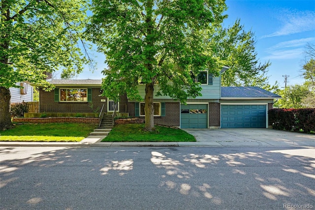 1905 S Linden Ct, Denver, CO 80224 - view of front facade with driveway, brick siding, an attached garage, and a front lawn