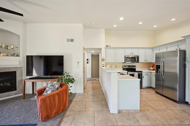 kitchen featuring a fireplace, appliances with stainless steel finishes, light tile patterned floors, and sink