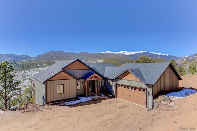 view of front facade featuring driveway, a mountain view, and board and batten siding