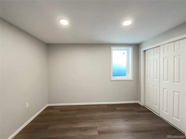 unfurnished bedroom with a closet and dark wood-type flooring