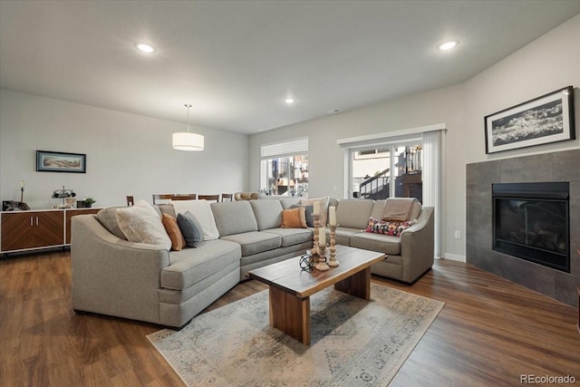 living room with a fireplace and dark wood-type flooring