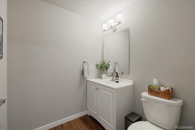 bathroom with vanity, wood-type flooring, and toilet