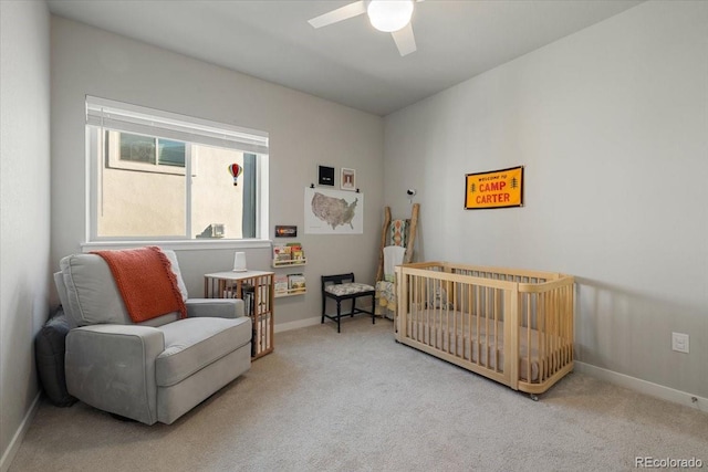 carpeted bedroom with a nursery area and ceiling fan