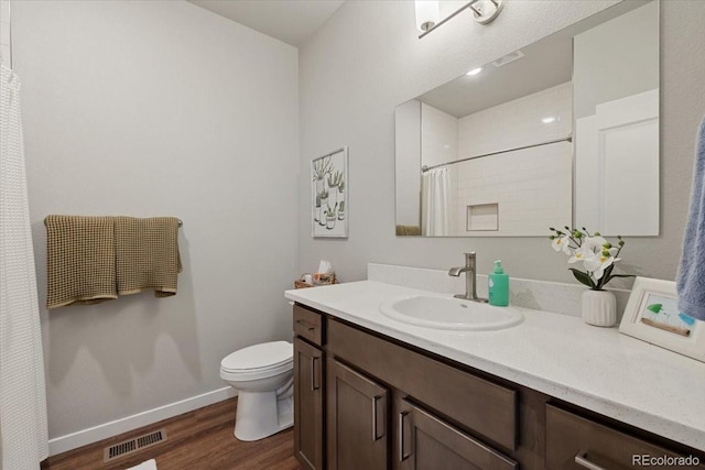 bathroom with toilet, vanity, and hardwood / wood-style flooring