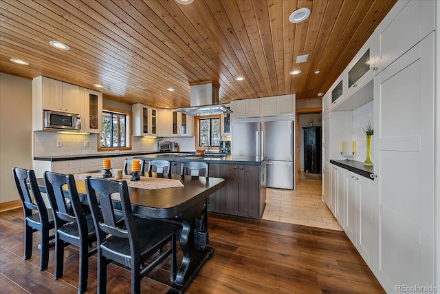 kitchen featuring appliances with stainless steel finishes, a center island, white cabinetry, tasteful backsplash, and dark hardwood / wood-style floors