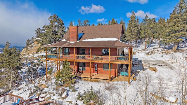 snow covered property with a wooden deck