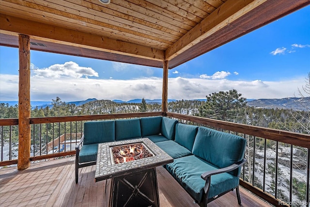 deck with a mountain view and an outdoor living space with a fire pit