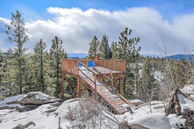 snow covered playground with a deck with mountain view