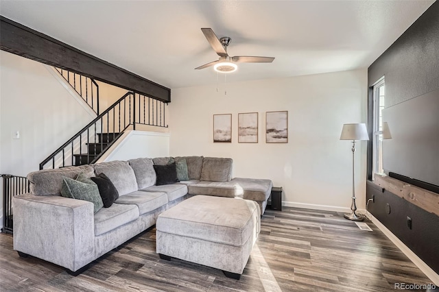 living room featuring dark wood-type flooring and ceiling fan