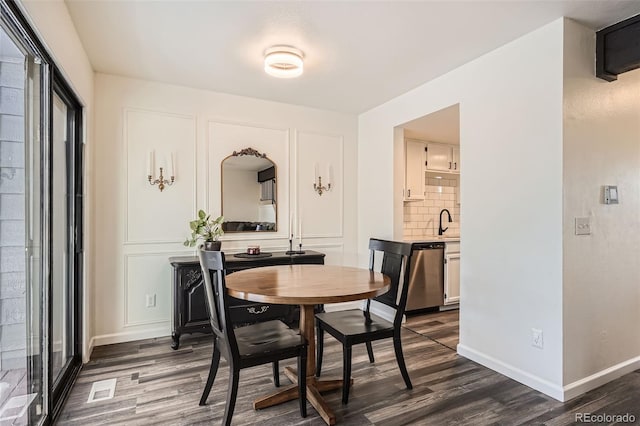 dining area featuring sink and dark hardwood / wood-style floors