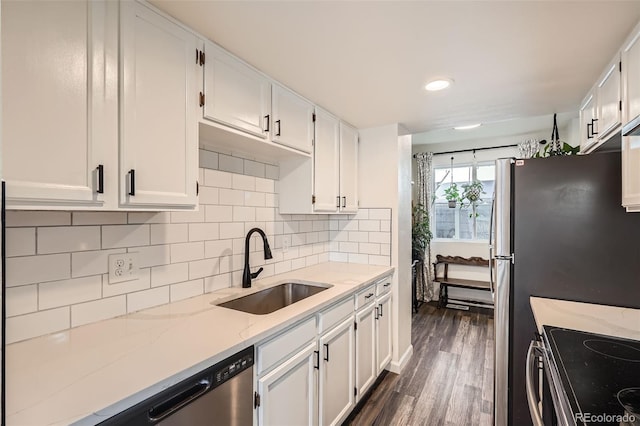 kitchen featuring dark wood-type flooring, sink, white cabinetry, light stone counters, and tasteful backsplash