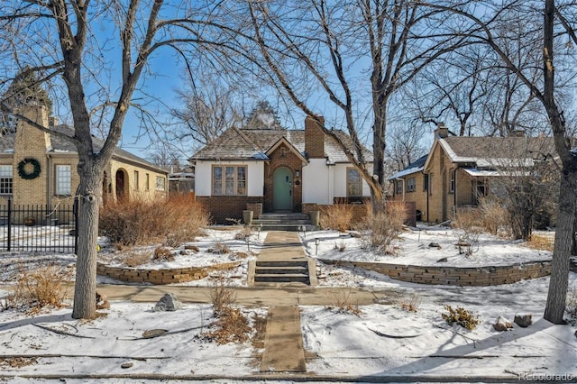 view of front of house featuring fence and brick siding