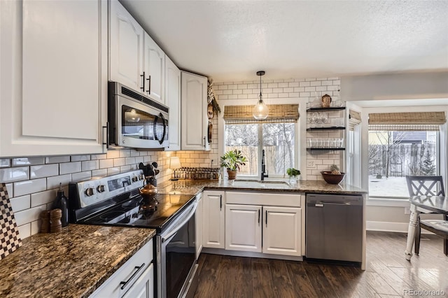 kitchen with decorative light fixtures, sink, white cabinetry, and appliances with stainless steel finishes