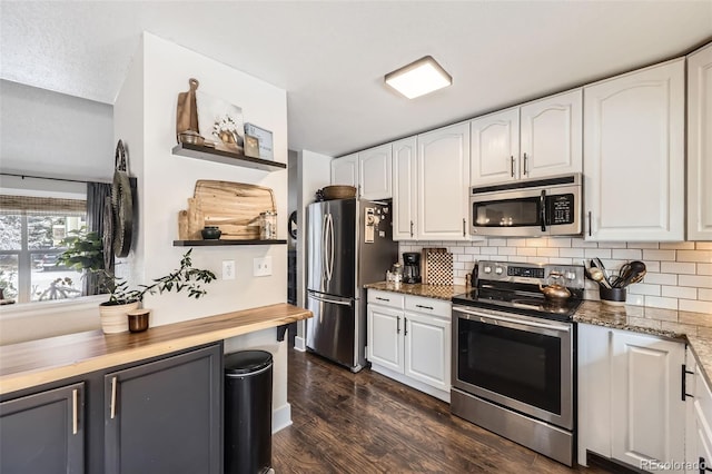 kitchen featuring white cabinets, dark hardwood / wood-style flooring, stainless steel appliances, and tasteful backsplash