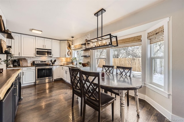 kitchen with white cabinets, pendant lighting, a healthy amount of sunlight, and stainless steel appliances