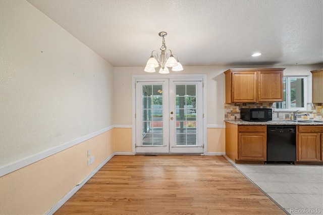8137 Vanguard Dr, Denver, CO 80221 - kitchen featuring black appliances, a chandelier, plenty of natural light, light wood finished floors, and a textured ceiling