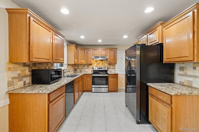 8137 Vanguard Dr, Denver, CO 80221 - kitchen featuring black appliances, under cabinet range hood, decorative backsplash, recessed lighting, and a sink