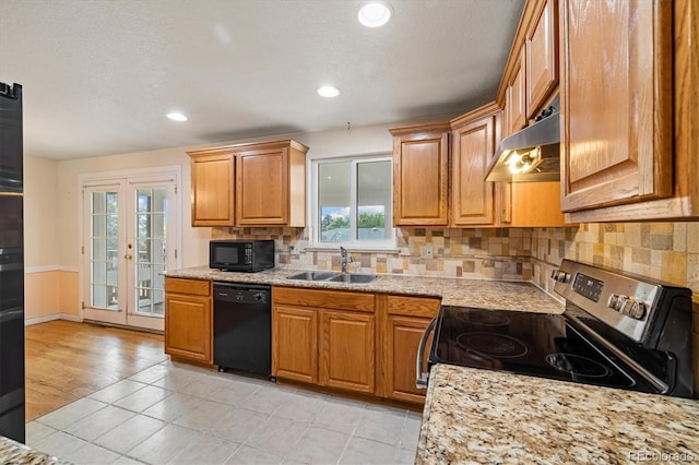 8137 Vanguard Dr, Denver, CO 80221 - kitchen featuring black appliances, under cabinet range hood, a sink, backsplash, and light tile patterned flooring