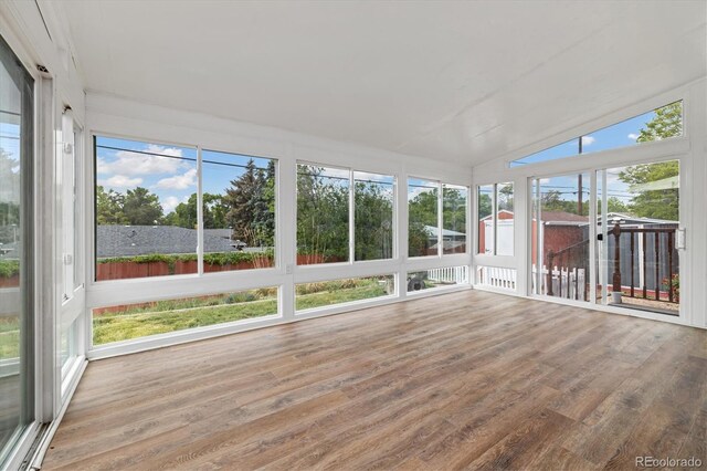 8137 Vanguard Dr, Denver, CO 80221 - unfurnished sunroom featuring wood finished floors, plenty of natural light, and vaulted ceiling
