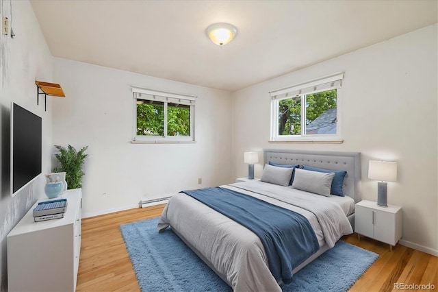 8137 Vanguard Dr, Denver, CO 80221 - bedroom featuring baseboard heating, light wood-style floors, and baseboards