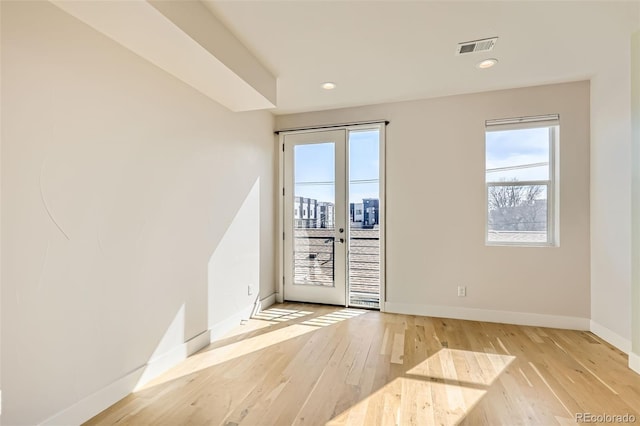 unfurnished room featuring recessed lighting, visible vents, light wood-style flooring, and baseboards