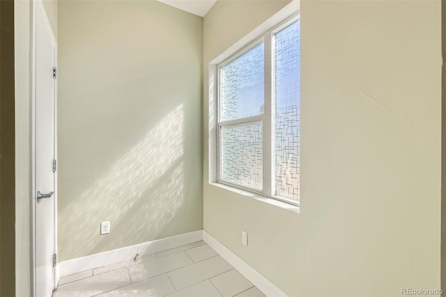 spare room featuring baseboards and light tile patterned floors