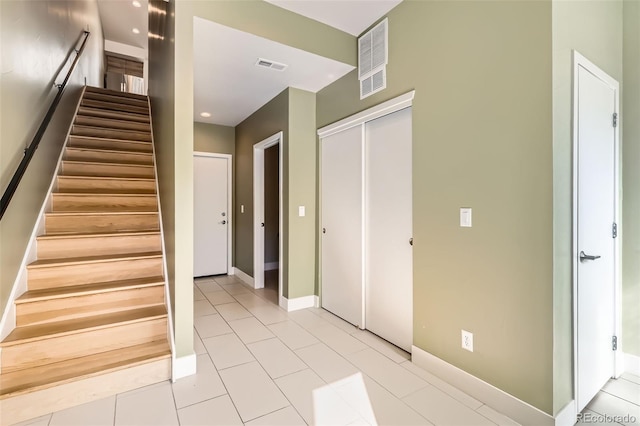 stairs featuring tile patterned flooring, visible vents, and baseboards