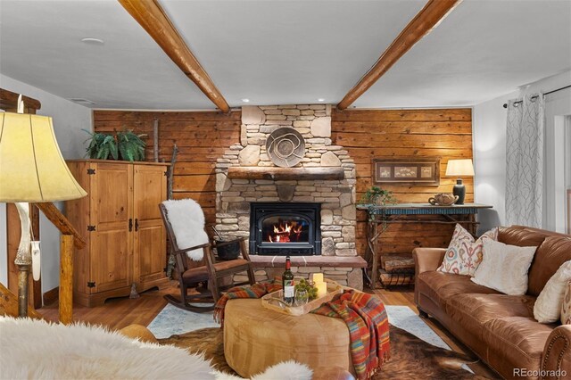 245 N County Highway 67, Sedalia, CO 80135 - living room featuring beam ceiling, wood finished floors, a stone fireplace, and wooden walls