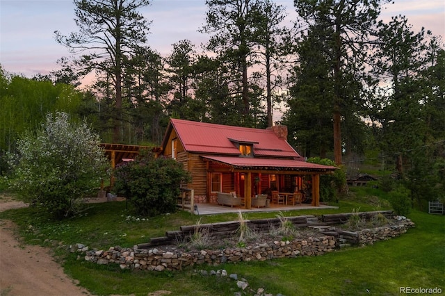 245 N County Highway 67, Sedalia, CO 80135 - back of house with a chimney, a yard, a patio area, a metal roof, and an outdoor hangout area